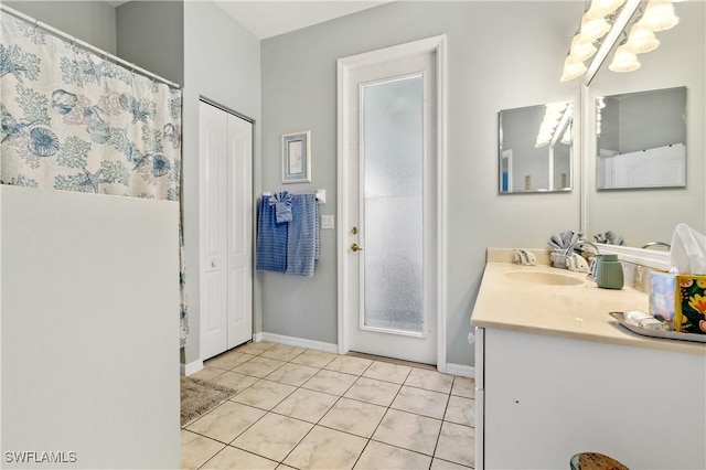 full bathroom with vanity, baseboards, tile patterned floors, and a chandelier