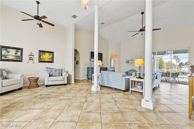 living area with high vaulted ceiling, a ceiling fan, arched walkways, and visible vents