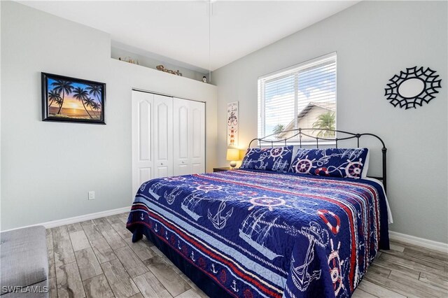 bedroom featuring a closet, baseboards, and wood finished floors