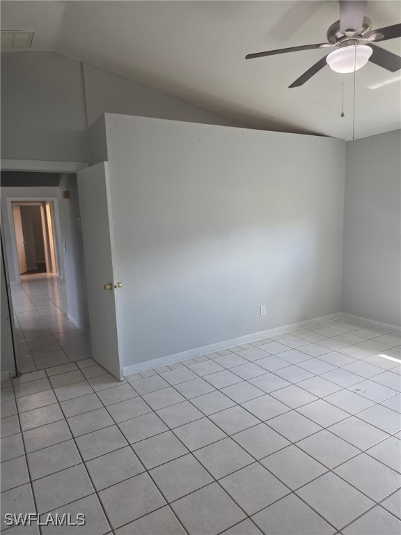 2123 NE 6th Pl, Cape Coral, FL 33909 - unfurnished room with baseboards, ceiling fan, light tile patterned floors, and vaulted ceiling