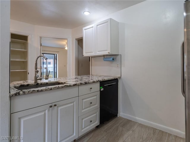 1228 SE 24th Ave Unit A, Cape Coral, FL 33990 - kitchen with black dishwasher, a sink, baseboards, white cabinets, and light stone countertops