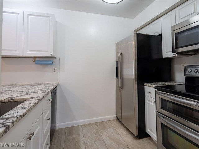 1228 SE 24th Ave Unit A, Cape Coral, FL 33990 - kitchen featuring appliances with stainless steel finishes, white cabinetry, light stone countertops, baseboards, and a sink