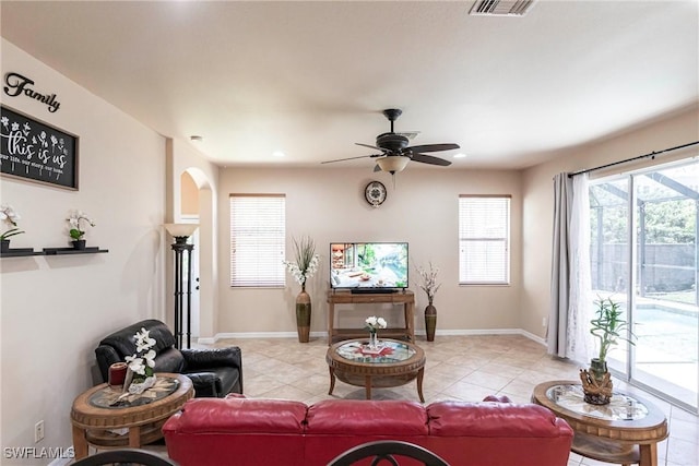 living room featuring arched walkways, ceiling fan, light tile patterned flooring, and visible vents