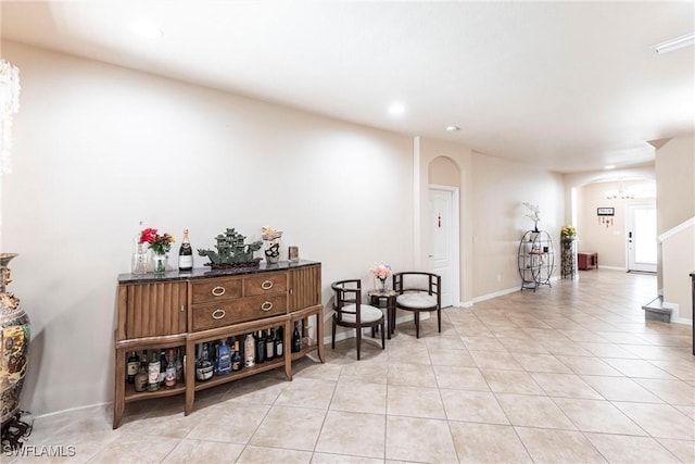 interior space featuring arched walkways, light tile patterned floors, baseboards, a notable chandelier, and recessed lighting