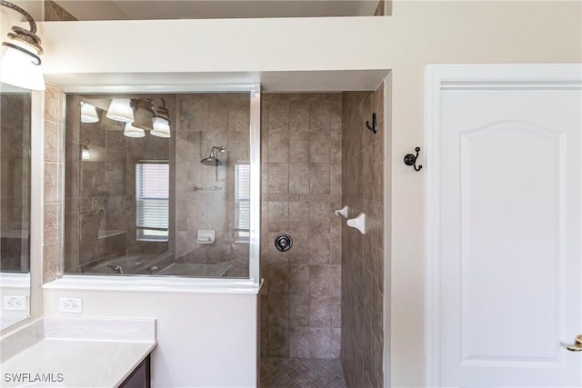 bathroom with walk in shower and vanity