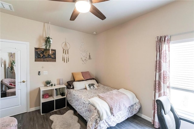 bedroom featuring baseboards, multiple windows, and wood finished floors