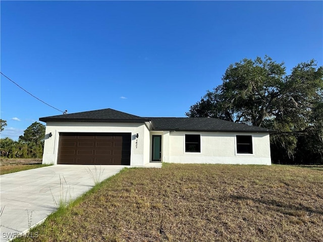 view of front of home with a garage, a front lawn, stucco siding, and driveway
