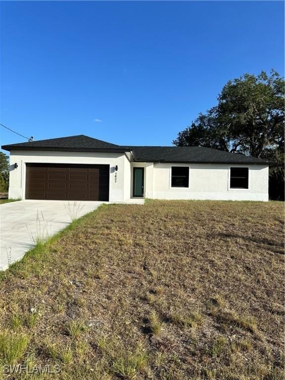 view of front facade with an attached garage, concrete driveway, and stucco siding