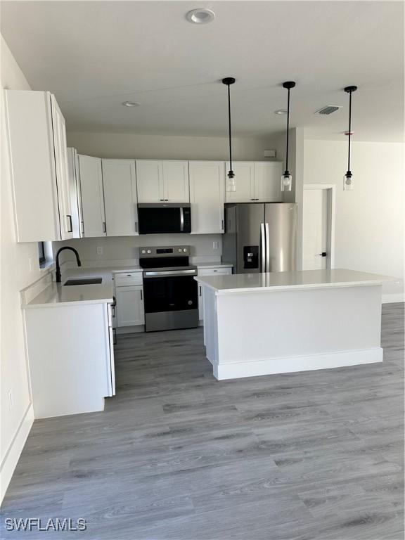 kitchen featuring white cabinetry, appliances with stainless steel finishes, a sink, and visible vents