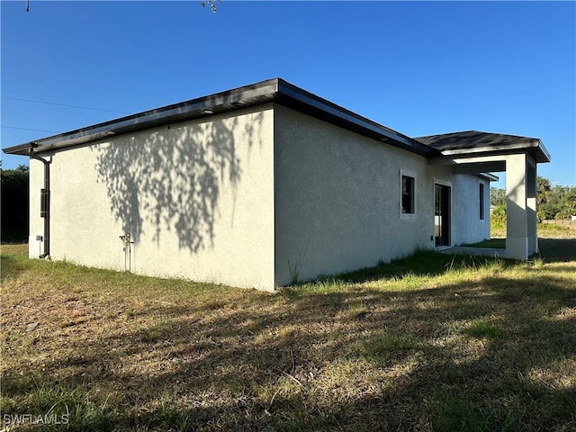 view of home's exterior with a lawn and stucco siding