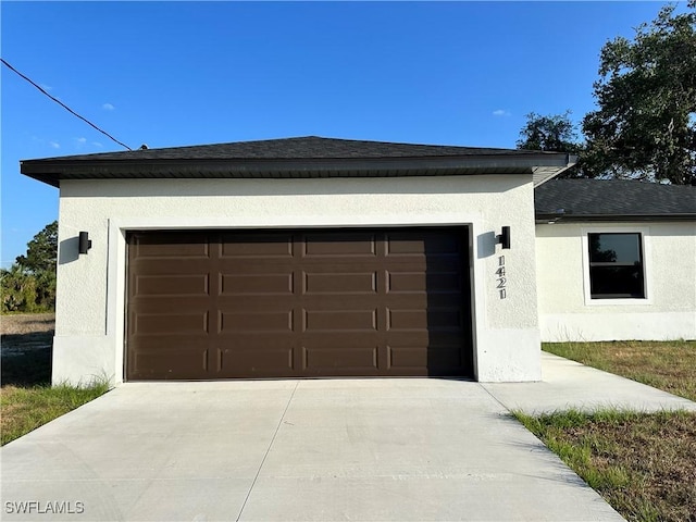 garage featuring concrete driveway