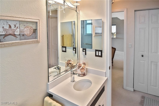 bathroom featuring a textured wall and vanity
