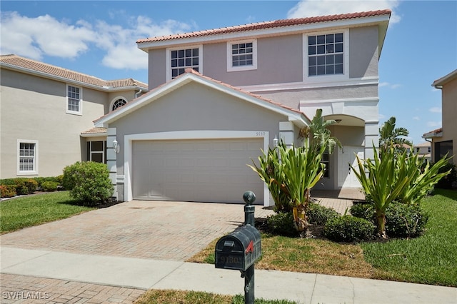 view of front of house featuring a garage, a front lawn, decorative driveway, stucco siding, and a tiled roof