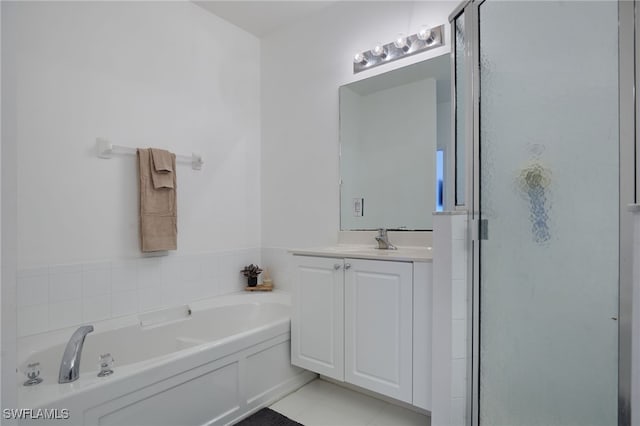 bathroom with a garden tub, vanity, tile patterned flooring, and a shower stall