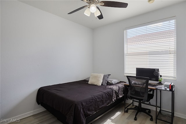 bedroom with baseboards, ceiling fan, and wood finished floors