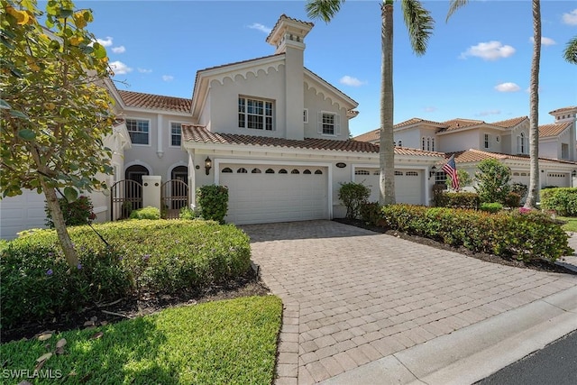9030 Cascada Way Unit 102, Naples, FL 34114 - mediterranean / spanish home featuring decorative driveway, a garage, a tile roof, and stucco siding