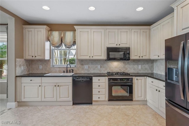9030 Cascada Way Unit 102, Naples, FL 34114 - kitchen featuring a sink, dark countertops, black appliances, and a wealth of natural light