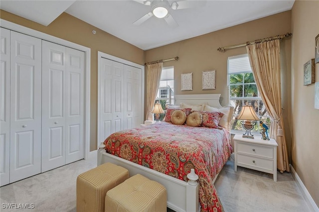 9030 Cascada Way Unit 102, Naples, FL 34114 - bedroom featuring light colored carpet, two closets, and multiple windows