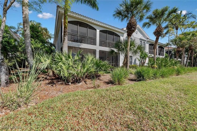 9030 Cascada Way Unit 102, Naples, FL 34114 - rear view of house featuring a lawn and a sunroom