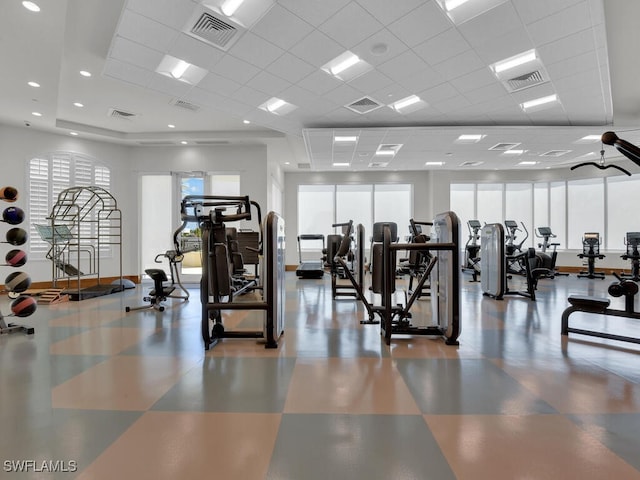 exercise room with a paneled ceiling and tile patterned floors