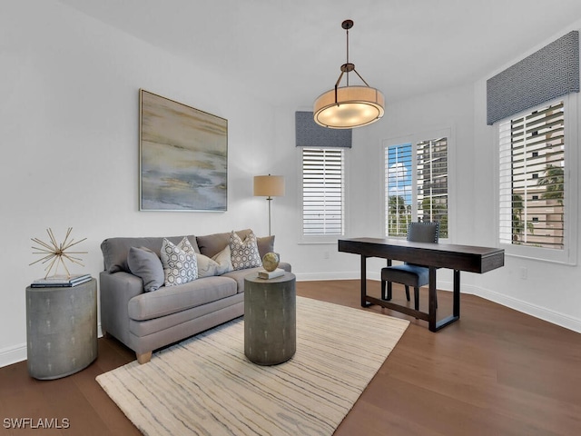 living area featuring dark wood-type flooring and baseboards