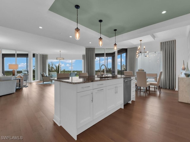 kitchen with a sink, dishwasher, dark wood-type flooring, open floor plan, and recessed lighting
