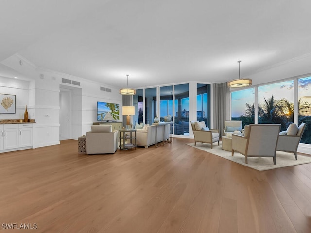 living room with light wood finished floors and ornamental molding