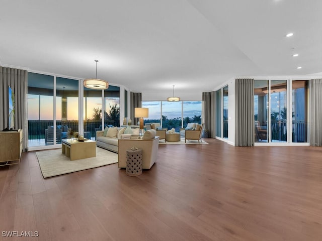 living room with a wall of windows and wood finished floors