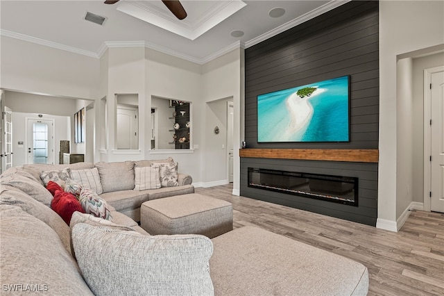 4424 Owens Way, Ave Maria, FL 34142 - living area featuring wood finished floors, a large fireplace, a ceiling fan, crown molding, and baseboards