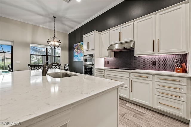 4424 Owens Way, Ave Maria, FL 34142 - kitchen featuring black electric cooktop, under cabinet range hood, a sink, ornamental molding, and white cabinets