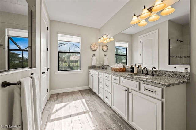 4424 Owens Way, Ave Maria, FL 34142 - full bathroom with double vanity, wood finished floors, baseboards, and a tile shower