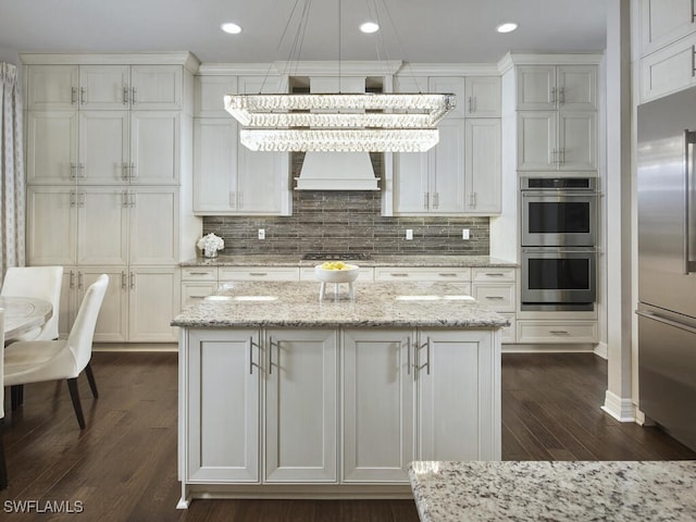 kitchen with appliances with stainless steel finishes, dark wood-type flooring, backsplash, custom range hood, and recessed lighting