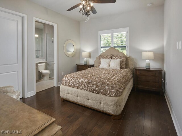 bedroom with baseboards, dark wood-style floors, ensuite bathroom, and a ceiling fan