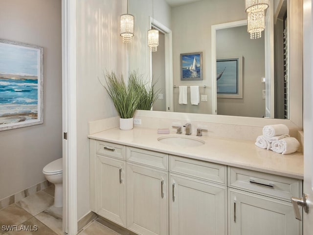 bathroom with toilet, vanity, tile patterned floors, a chandelier, and baseboards