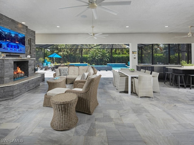 view of patio featuring ceiling fan, outdoor dining area, an outdoor pool, and an outdoor stone fireplace
