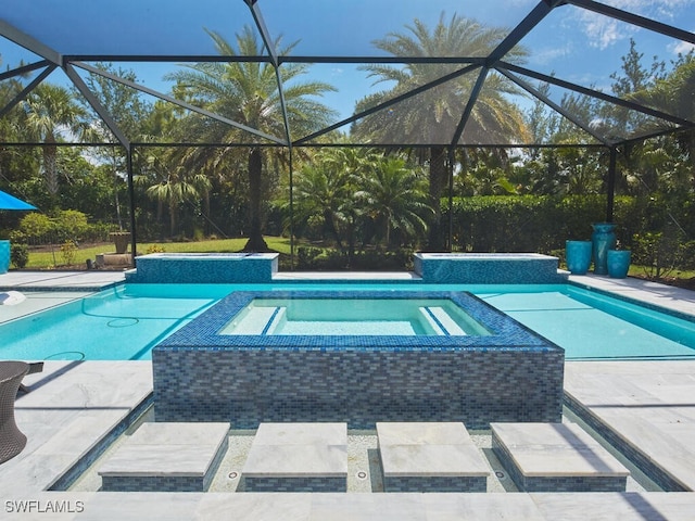 view of swimming pool featuring a pool with connected hot tub, glass enclosure, and a patio area