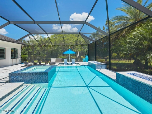 view of pool with a pool with connected hot tub, a patio, and a lanai