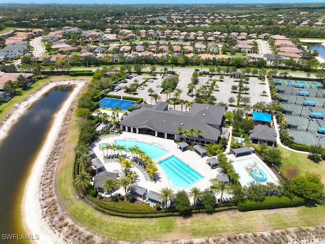 aerial view of residential area featuring a pool and a nearby body of water