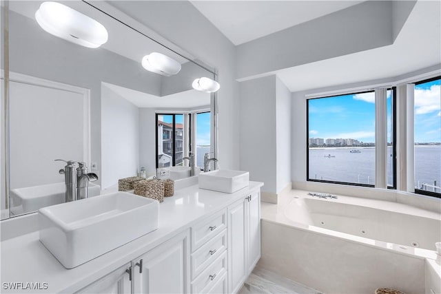 410 La Peninsula Blvd Unit 410, Naples, FL 34113 - full bathroom with a sink, a water view, a tub with jets, and double vanity