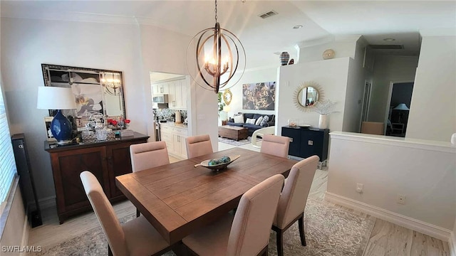 dining space featuring visible vents, crown molding, light wood-style floors, baseboards, and a notable chandelier