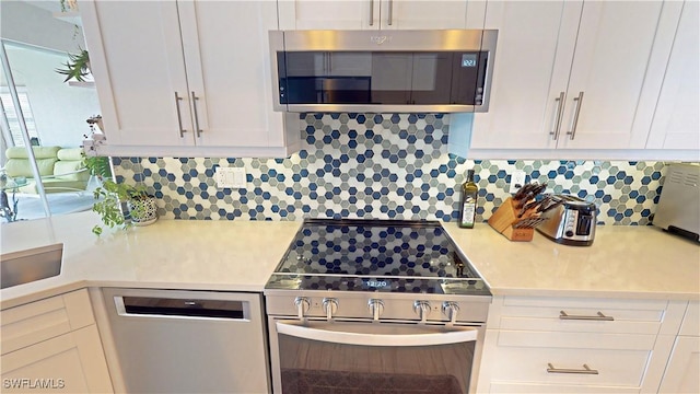 kitchen featuring light countertops, appliances with stainless steel finishes, tasteful backsplash, and white cabinetry