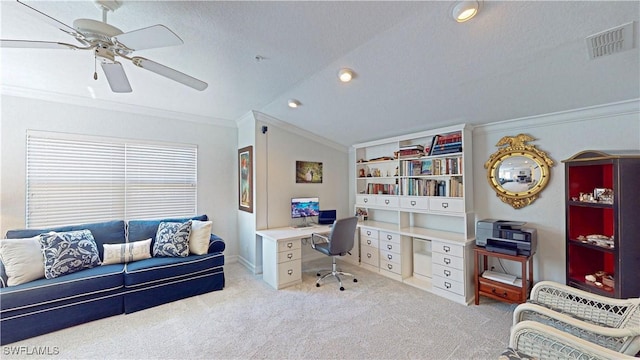 home office with a ceiling fan, visible vents, vaulted ceiling, ornamental molding, and carpet