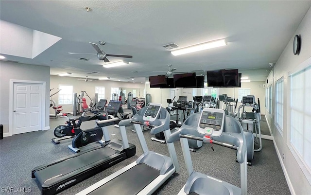 exercise room featuring visible vents, a ceiling fan, and baseboards