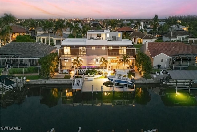 724 Plantation Ct, Marco Island, FL 34145 - back of house at dusk featuring a residential view, boat lift, and a water view