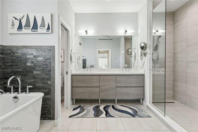 724 Plantation Ct, Marco Island, FL 34145 - full bathroom featuring a freestanding tub, a tile shower, double vanity, tile patterned floors, and toilet