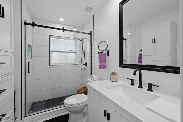 bathroom featuring vanity, toilet, recessed lighting, a shower stall, and visible vents