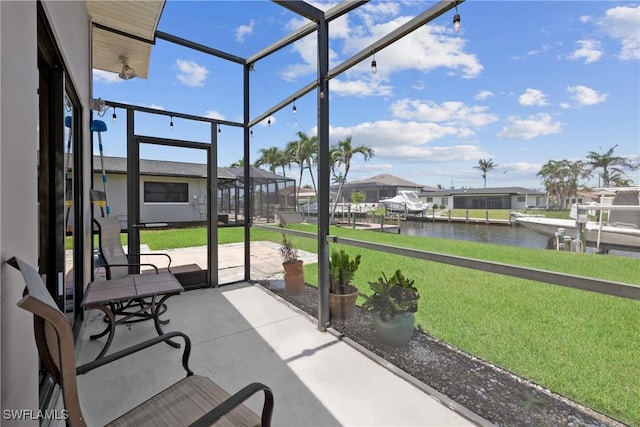 sunroom featuring a water view and a residential view