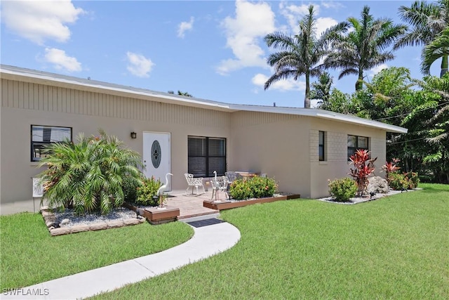 back of property featuring a yard and stucco siding