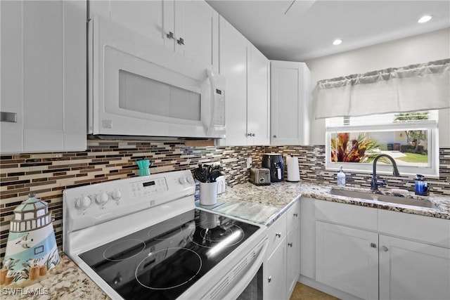 kitchen featuring a sink, white cabinetry, white appliances, and tasteful backsplash