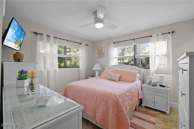 bedroom featuring baseboards, multiple windows, and a ceiling fan